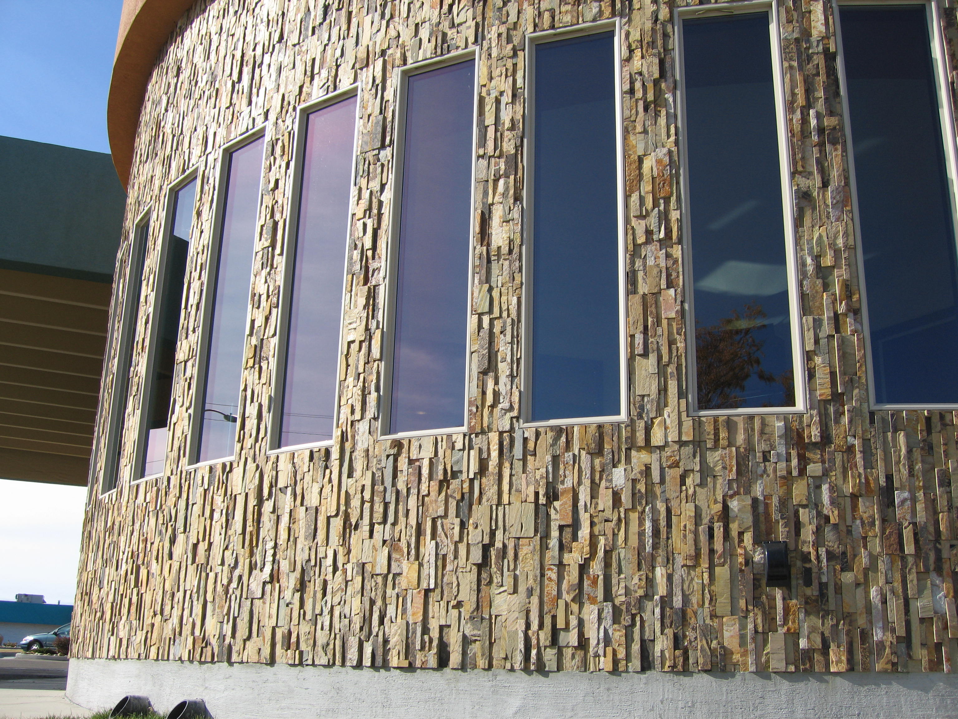 Norstone Ochre Blend Rock Panels installed on a vertical orientation on an exterior convex radius wall